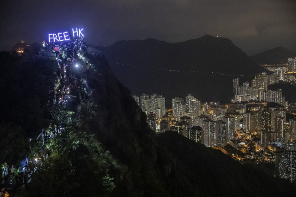 Athit Perawongmetha. معترضان هنگ‌کنگی روی قله کوه مشرف به شهر هنگ‌کنگ نوشته‌ی «هنگ‌کنگ را آزاد کنید» روشن کرده‌اند. 