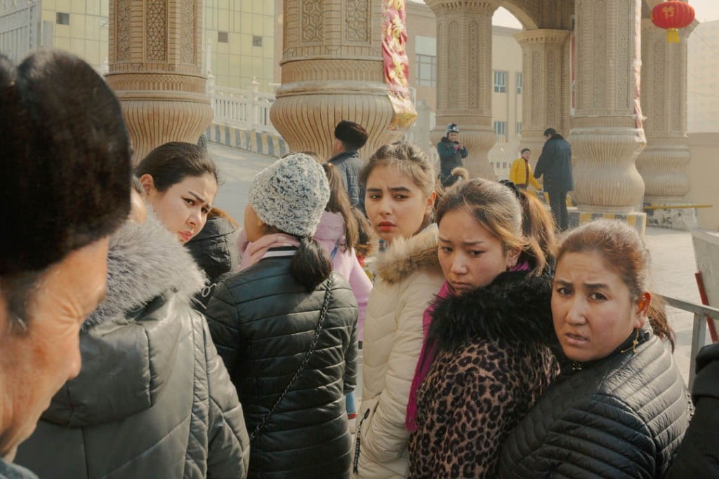 پاتریک وک. محلی‌های اقلیت اویغور در صف منتظر بررسی کارت شناسایی و بازرسی بدنی پیش از ورود به بازار محلی، شهر خوتەن، استان سین‌کیانگ، 3 فوریه 2019