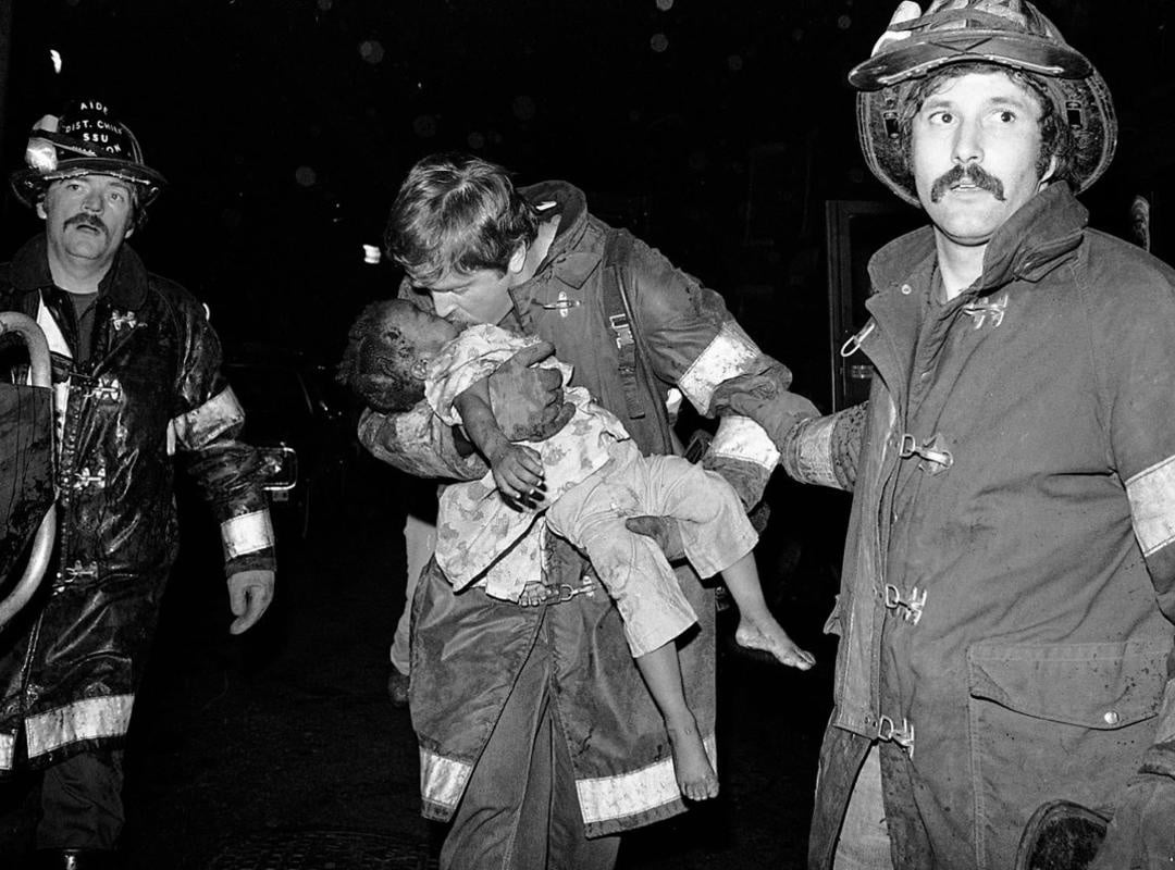 Stanley Forman. آتش‌نشان سعی در احیاء دهان‌به‌دهان کودک سقوط کرده دارد.